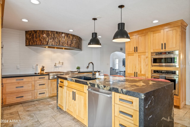 kitchen featuring arched walkways, light brown cabinetry, a sink, and stainless steel appliances
