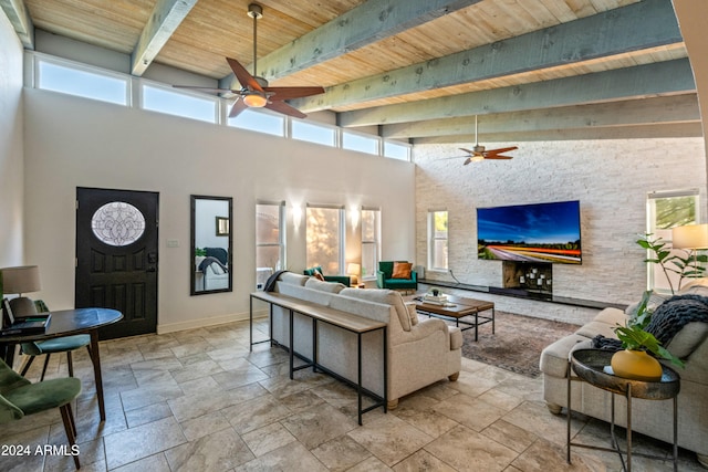 living area featuring stone tile floors, a high ceiling, and ceiling fan