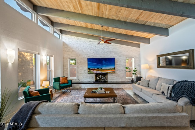 living room featuring beam ceiling, wooden ceiling, ceiling fan, and a high ceiling