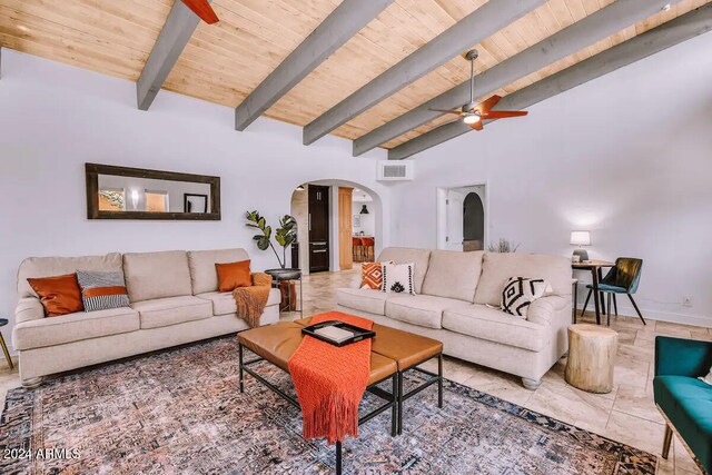 living area featuring arched walkways, vaulted ceiling with beams, visible vents, ceiling fan, and wooden ceiling