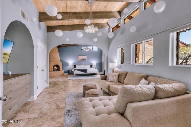 living room featuring an inviting chandelier, wood ceiling, beamed ceiling, and a fireplace