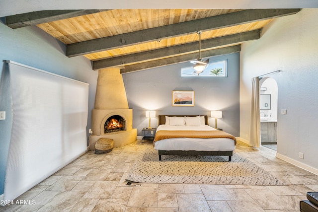 bedroom with wood ceiling, high vaulted ceiling, connected bathroom, beamed ceiling, and a fireplace