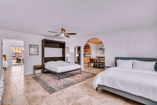 bedroom with arched walkways, visible vents, a ceiling fan, and baseboards