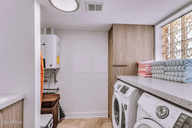 laundry area with tankless water heater and washing machine and dryer