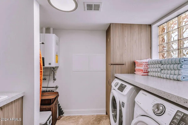laundry room with water heater, visible vents, separate washer and dryer, and laundry area