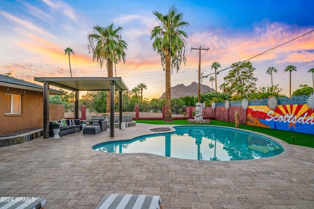 pool at dusk featuring a patio area, a fenced in pool, a fenced backyard, and an outdoor living space