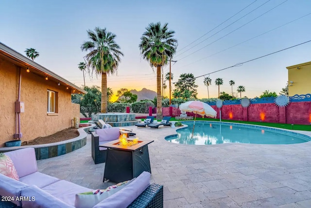 pool at dusk with a patio area and an outdoor hangout area