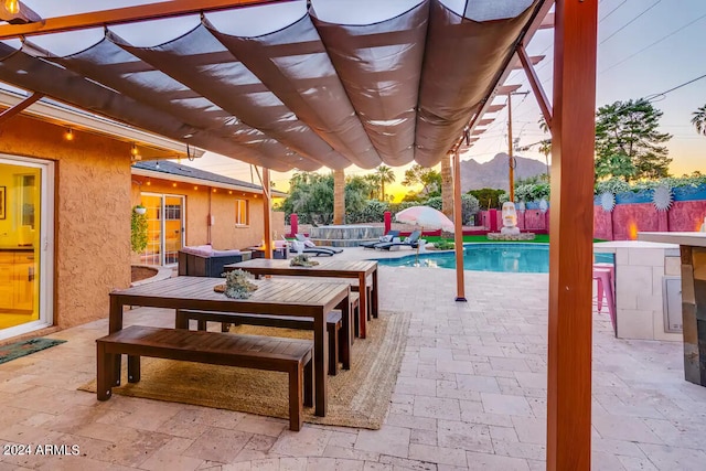 patio terrace at dusk with a fenced backyard, a pergola, outdoor dining space, and a fenced in pool