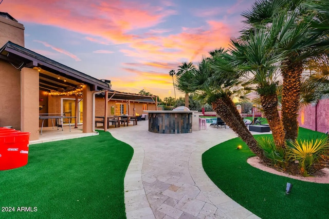 yard at dusk with a patio area and a jacuzzi