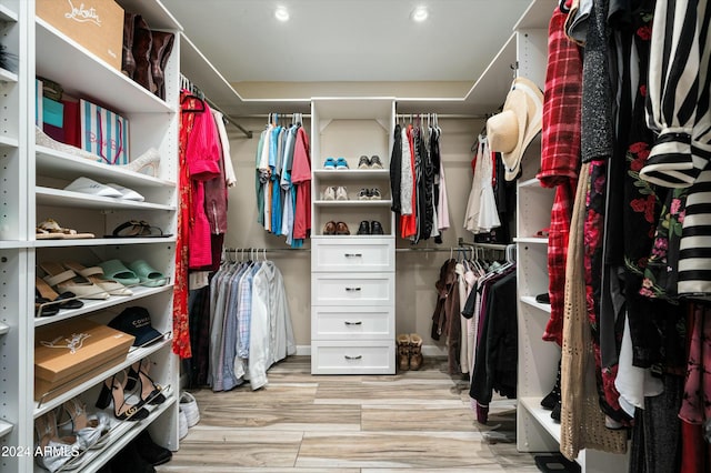 walk in closet with light hardwood / wood-style flooring