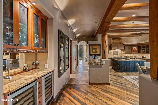 kitchen featuring beam ceiling, wine cooler, a kitchen island, and dark hardwood / wood-style floors