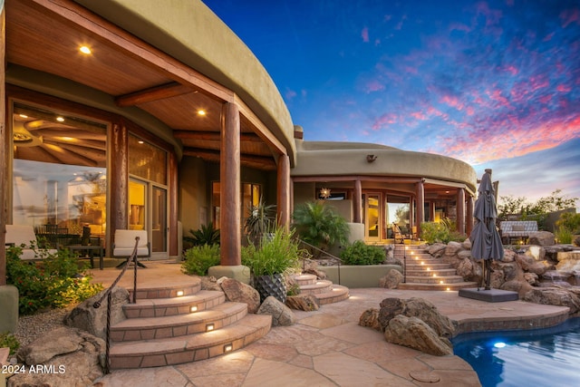 back house at dusk with a patio