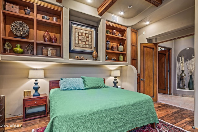 bedroom featuring beam ceiling and dark wood-type flooring