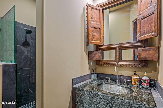 bathroom featuring a tile shower and vanity