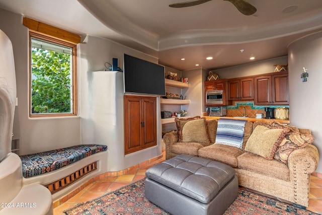 tiled living room featuring ceiling fan and sink