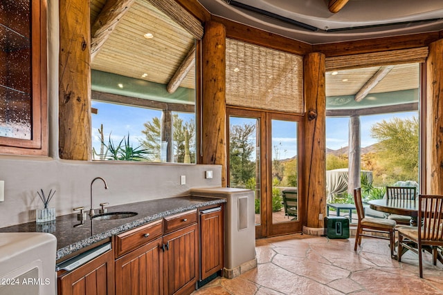 kitchen with a mountain view, beam ceiling, wood ceiling, and sink