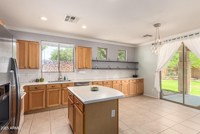 kitchen featuring sink, appliances with stainless steel finishes, a kitchen island, decorative light fixtures, and light tile patterned flooring