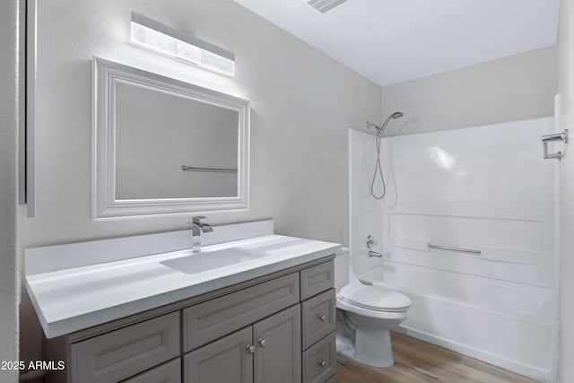 full bathroom with hardwood / wood-style flooring, vanity, shower / bathtub combination, and toilet