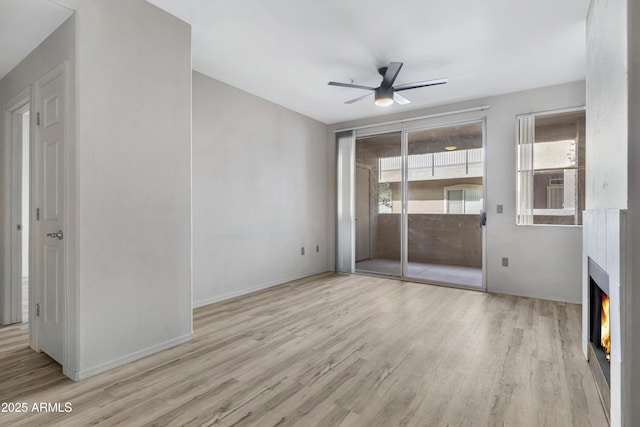 unfurnished living room featuring ceiling fan and light hardwood / wood-style flooring