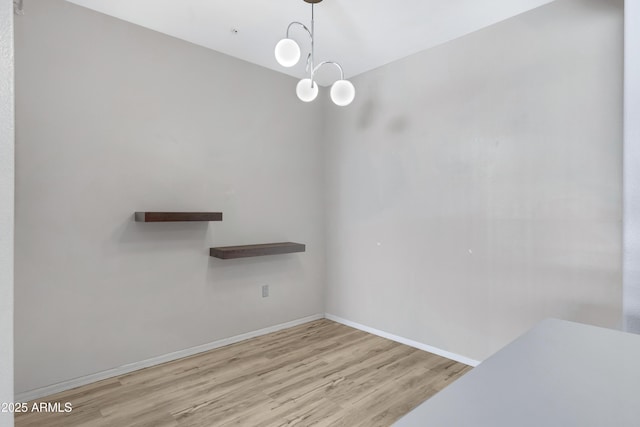 unfurnished dining area featuring light hardwood / wood-style floors and an inviting chandelier