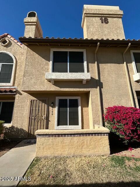 exterior space featuring a chimney and stucco siding