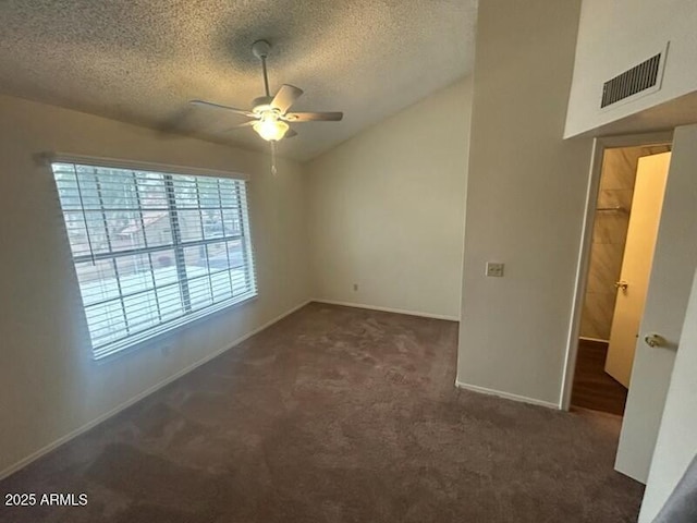 empty room with a textured ceiling, visible vents, a ceiling fan, lofted ceiling, and carpet floors