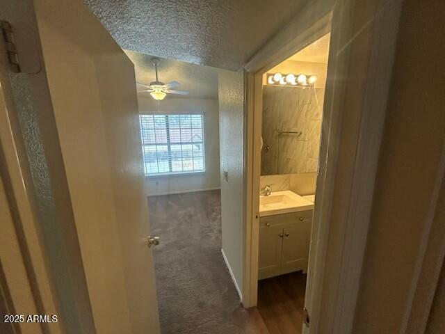 bathroom with baseboards, a ceiling fan, vanity, and a textured ceiling