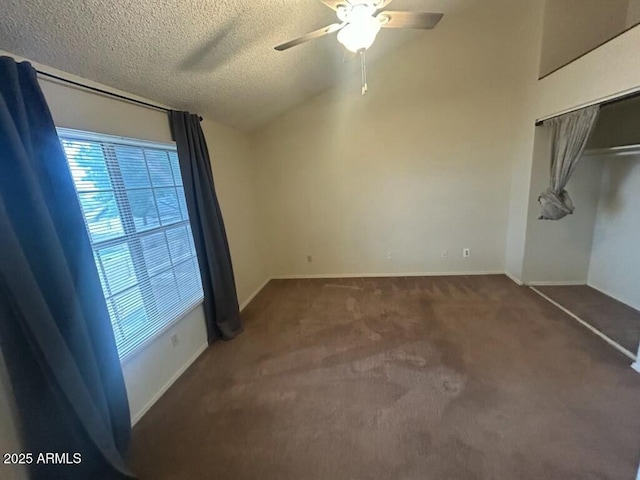 unfurnished bedroom featuring vaulted ceiling, carpet, baseboards, a textured ceiling, and ceiling fan