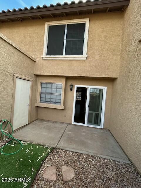 rear view of property featuring stucco siding and a patio area