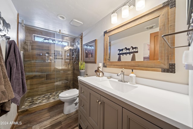 full bathroom featuring vanity, wood finished floors, visible vents, a stall shower, and toilet