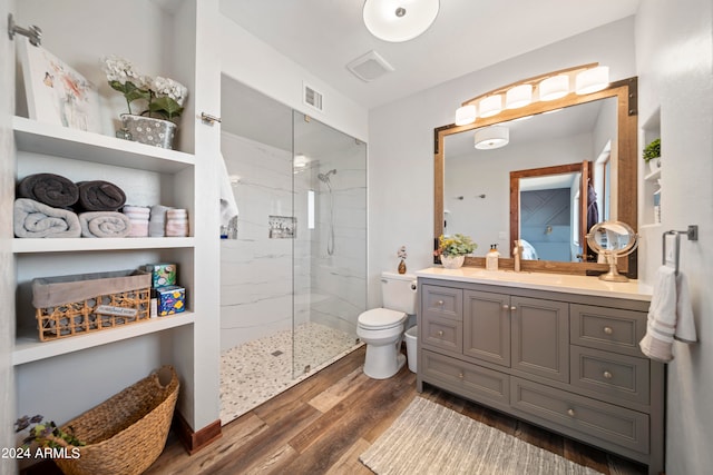 full bath featuring vanity, wood finished floors, visible vents, a marble finish shower, and toilet