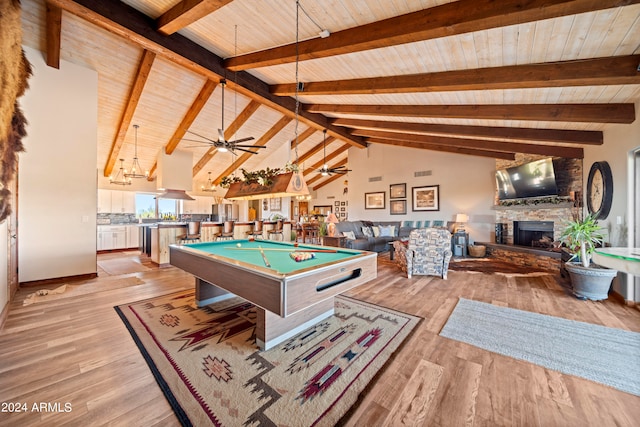 game room featuring beamed ceiling, light wood-style flooring, a stone fireplace, wooden ceiling, and pool table