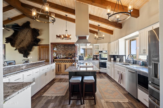 kitchen with tasteful backsplash, appliances with stainless steel finishes, wooden ceiling, and light stone counters