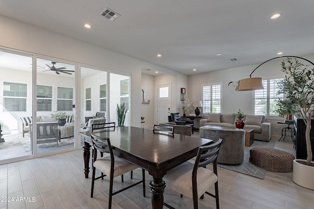 dining space with ceiling fan and light hardwood / wood-style flooring