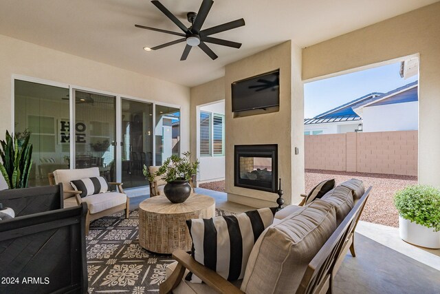 view of patio / terrace featuring an outdoor living space with a fireplace and ceiling fan