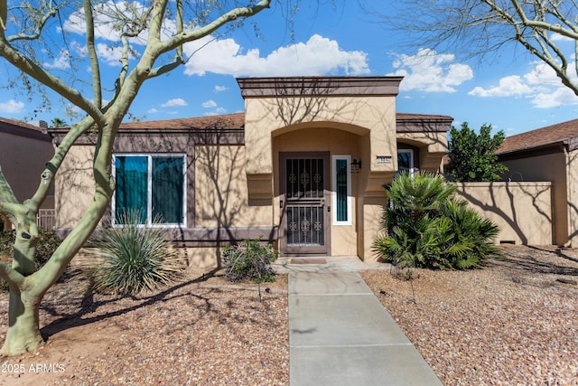 property entrance featuring stucco siding and fence