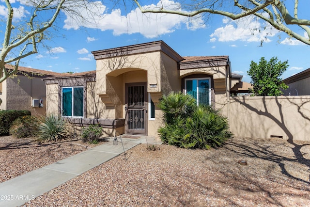 view of front facade featuring fence and stucco siding