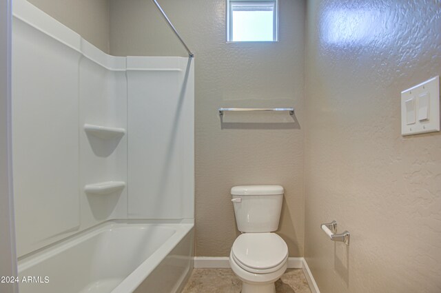 bathroom featuring tile patterned flooring, tub / shower combination, and toilet