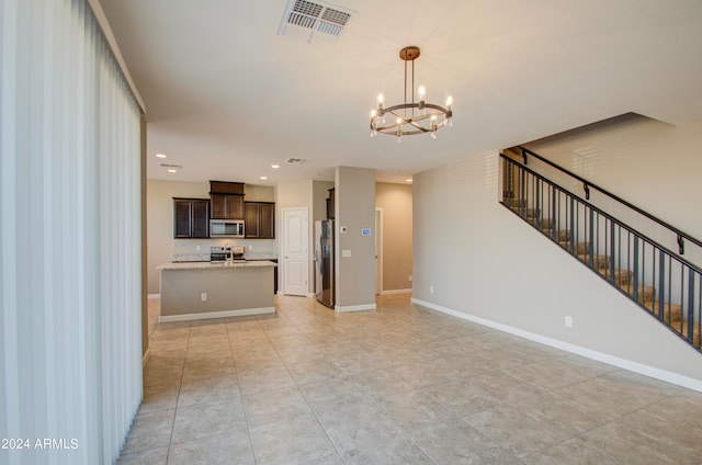 unfurnished living room featuring light tile patterned flooring and a chandelier