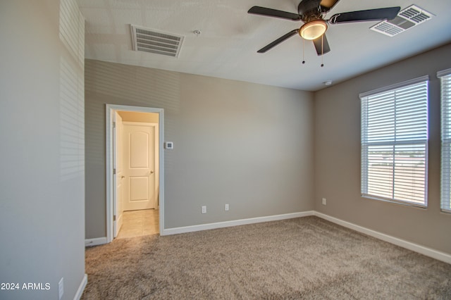 carpeted spare room with ceiling fan