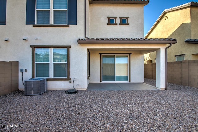 rear view of house with central AC unit and a patio area