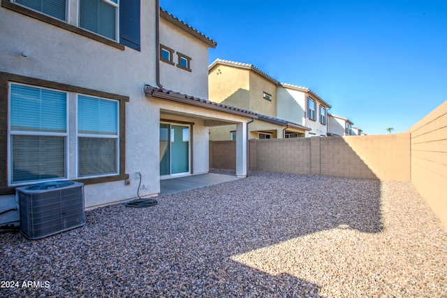 rear view of property with cooling unit and a patio area