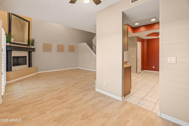 4202 N 21st St Unit 1, Phoenix, AZ 85016 - unfurnished living room featuring ceiling fan, light wood-style flooring, stairs, recessed lighting, and a tile fireplace