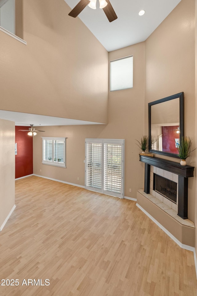 4202 N 21st St Unit 1, Phoenix, AZ 85016 - unfurnished living room with a ceiling fan, a towering ceiling, wood finished floors, recessed lighting, and a tile fireplace