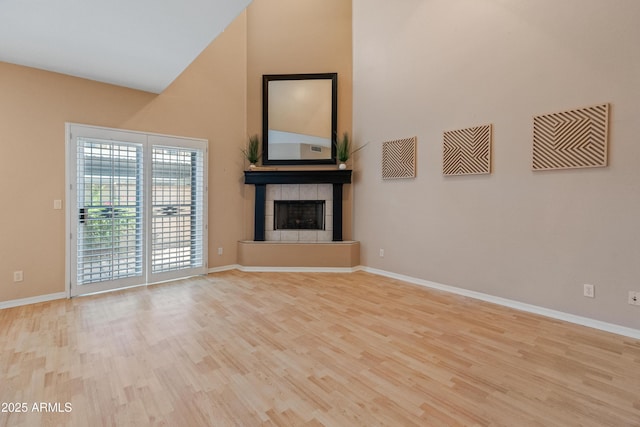 4202 N 21st St Unit 1, Phoenix, AZ 85016 - unfurnished living room featuring high vaulted ceiling, wood finished floors, and a fireplace with raised hearth