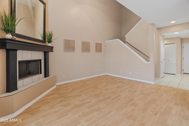 4202 N 21st St Unit 1, Phoenix, AZ 85016 - unfurnished living room featuring wood finished floors, recessed lighting, a tiled fireplace, and stairs
