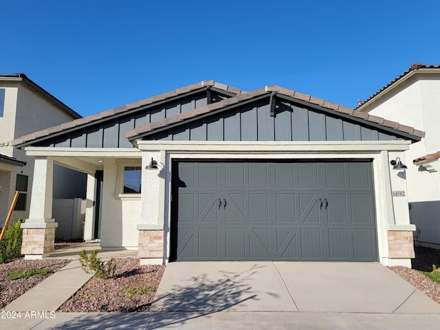 13247 N 145th Ln, Surprise, AZ 85379 - view of front facade with board and batten siding, an attached garage, driveway, and stucco siding