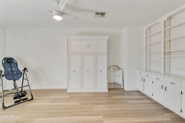 exercise area with ceiling fan and light hardwood / wood-style floors