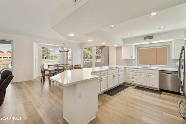 kitchen with a wealth of natural light, dishwasher, and kitchen peninsula