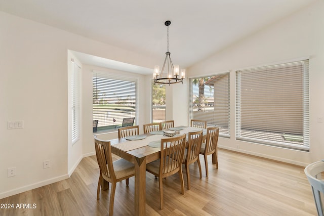 dining area featuring light hardwood / wood-style floors, lofted ceiling, and a notable chandelier